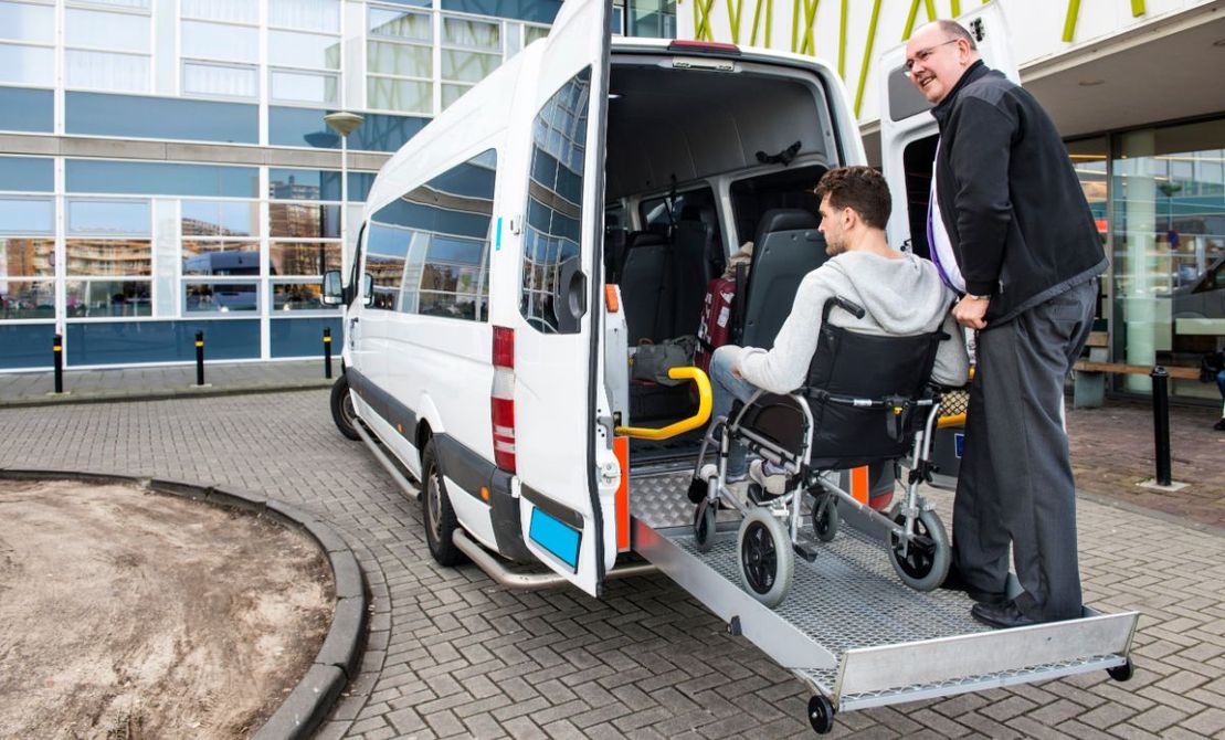Taxista llevando al hospital a una persona en silla de ruedas